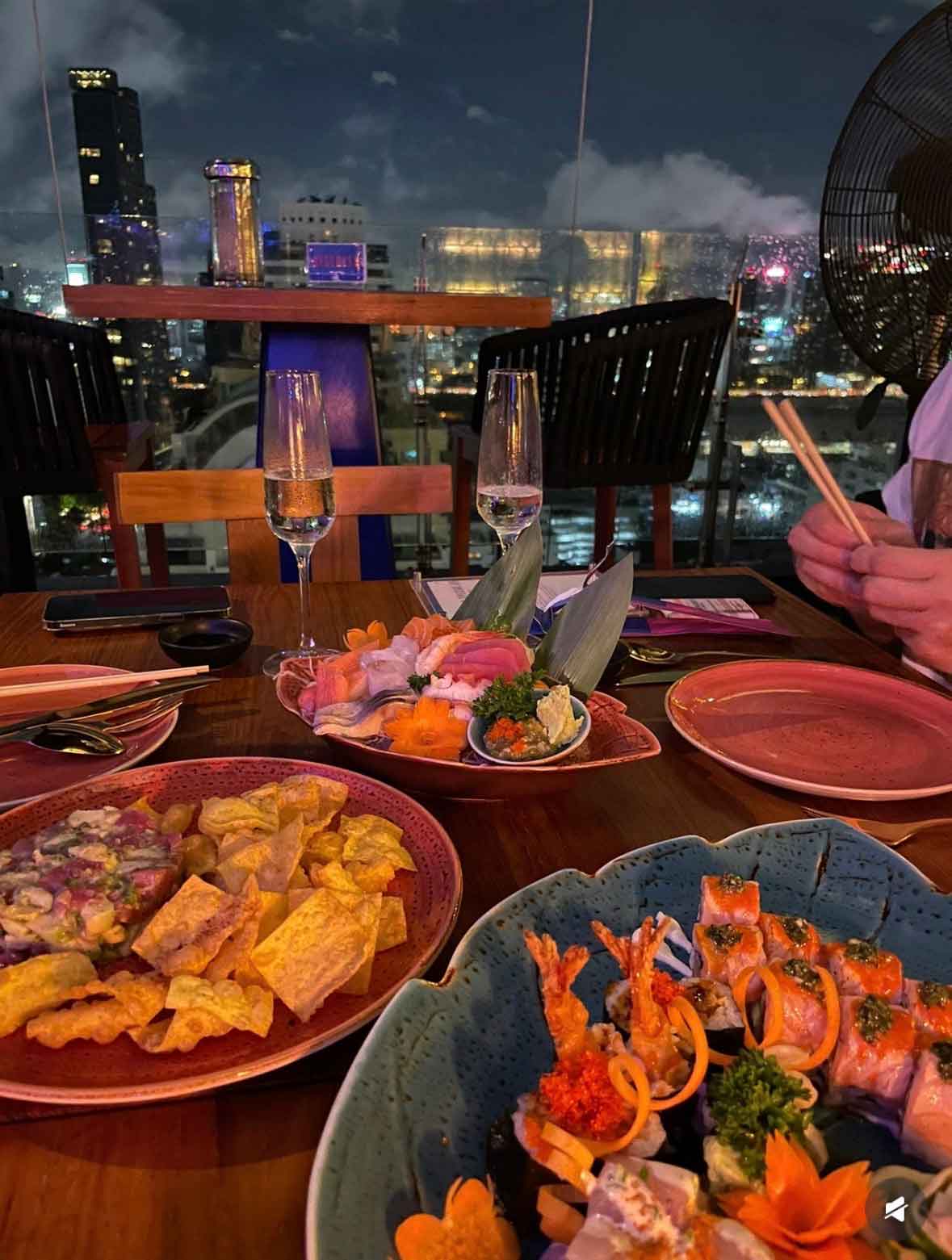 ซาชิมิและเครื่องดื่มบนโต๊ะที่ Above Eleven Rooftop Bar